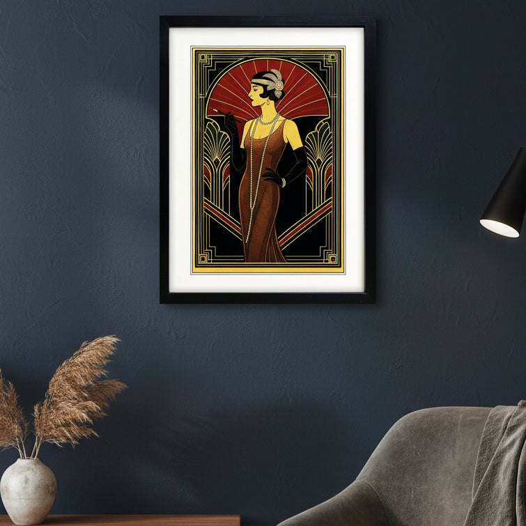 Framed art print featuring an Art Deco style illustration of a 1920s flapper woman in a brown dress, wearing a black hat, gloves, and necklace, set against a red and black background with gold geometric borders. The print is framed in black with a white mat.