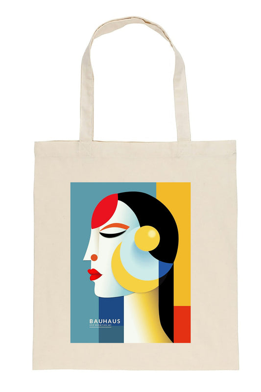 A cream-colored canvas tote bag featuring a Bauhaus-style geometric art print of a woman's profile with red, yellow, black, and blue shapes. The text 'BAUHAUS' is printed in white near the bottom of the graphic.