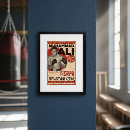 A framed vintage-style poster featuring Muhammad Ali as a boxing advertisement, shown against a plain white background. The poster has a cream background with red and black text and an illustration of Ali wearing boxing gloves.