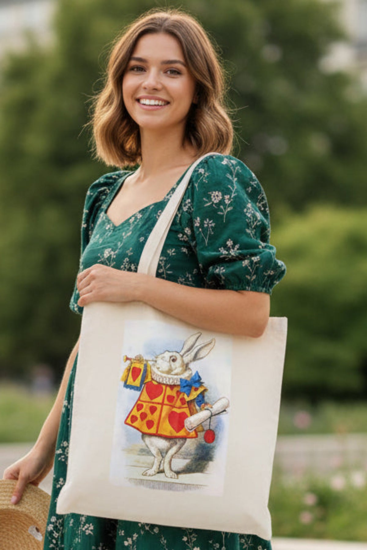 A natural canvas tote bag featuring a printed illustration of the White Rabbit in a red and yellow heart-patterned jacket, holding a scroll and a small bag, set against a plain white background.