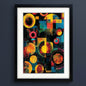 Framed abstract geometric art print featuring overlapping circles, squares, and angular shapes in yellow, orange, red, teal, green, and black, presented in a black frame with white matting against a light gray background.