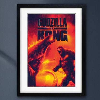 A framed Godzilla vs Kong movie poster hanging on a dark gray wall. The poster features Godzilla and Kong in a fiery battle scene with bold black title text at the top.