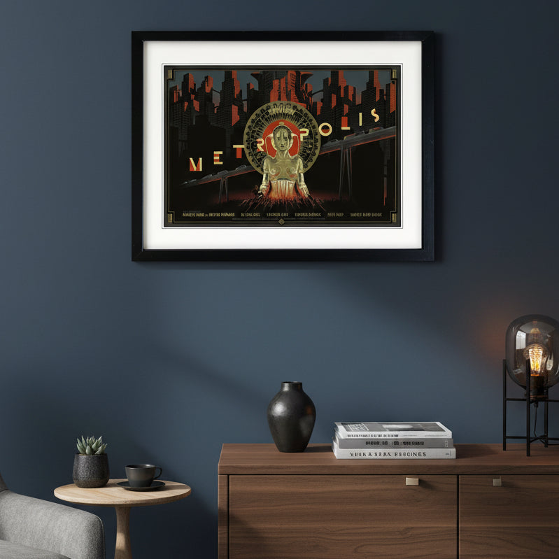 A framed art print of the 1954 sci-fi film 'Metropolis' featuring a stylized poster design with a metallic gold robot, red and black city skyline, and a white mat board, enclosed in a black frame.
