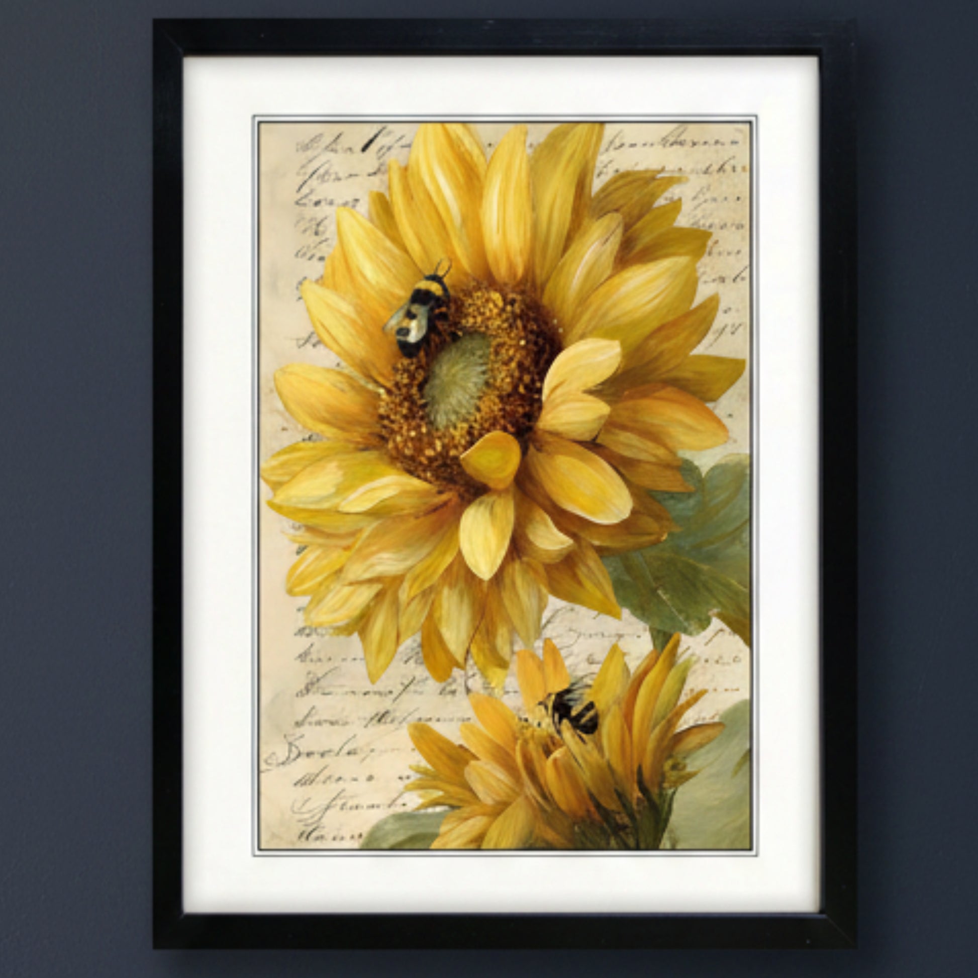 Framed wall art featuring a vintage-style print of two yellow sunflowers with bumblebees on a beige script background, enclosed in a black frame with white matting.