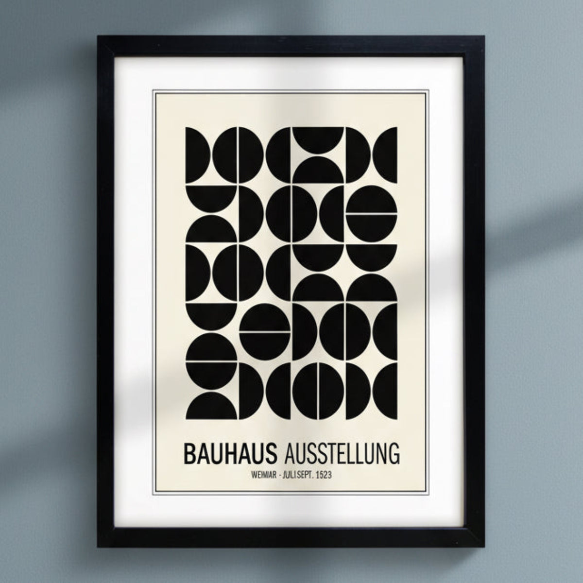 Bauhaus print hung on dark blue wall  natural sunlight 