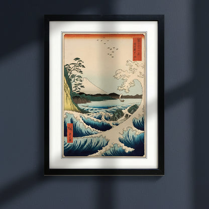 Framed Japanese style ocean waves and mountain art print shown with a white mat and black frame on a dark blue background.