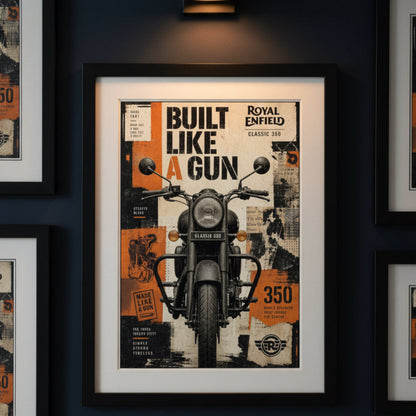 A framed wall art print featuring a vintage Royal Enfield motorcycle poster, hung on a dark navy wall. The poster has a black frame, white mat, and an orange, black, and white collage design with the text 'BUILT LIKE A GUN' and 'ROYAL ENFIELD'.