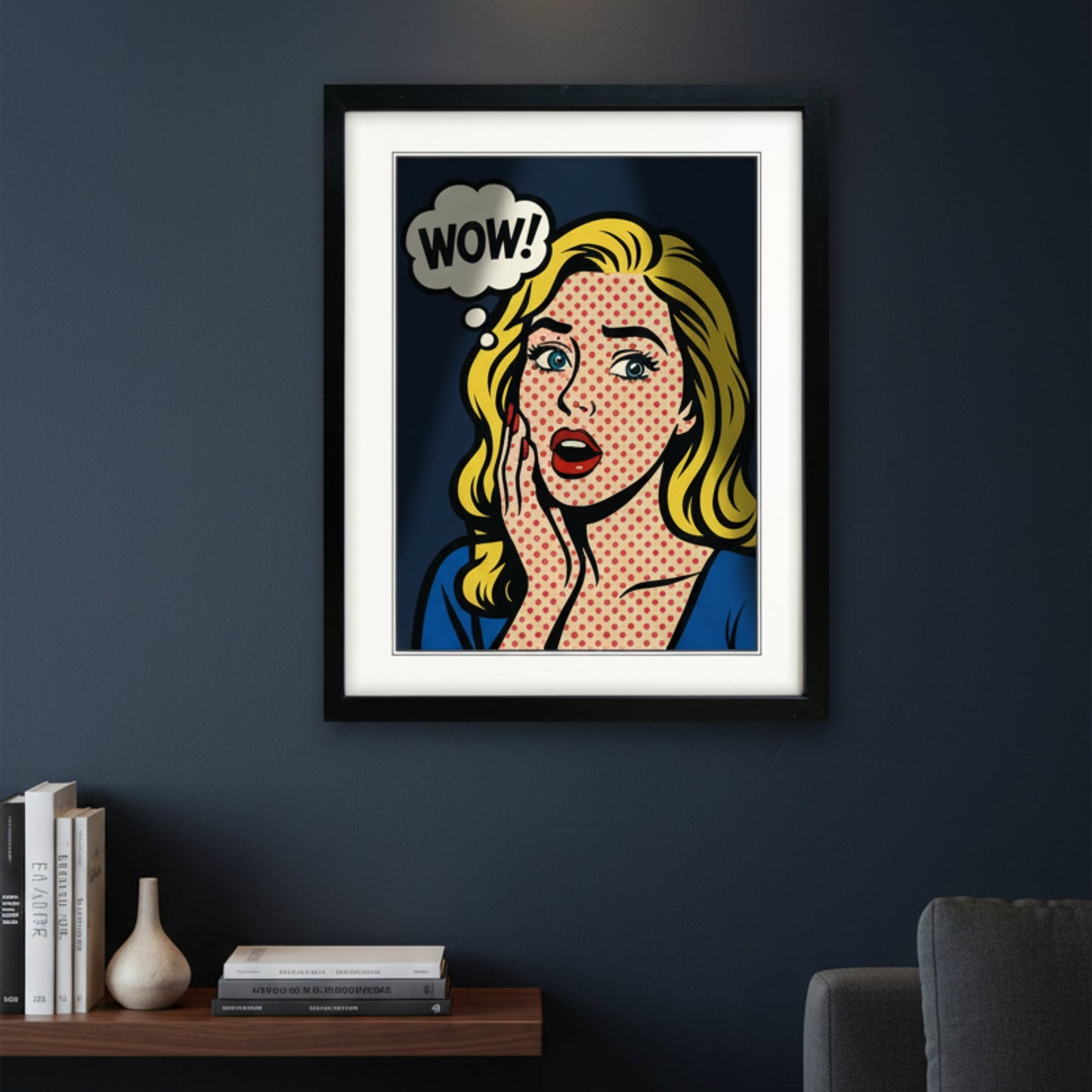 A framed pop-art print featuring a blonde woman with a halftone dot pattern, a speech bubble that says 'WOW!', and a red polka-dot background, shown in a black frame against a white wall.