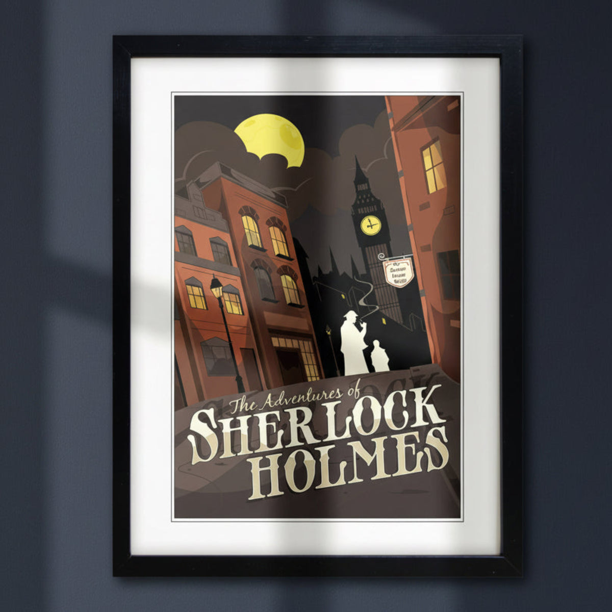 A framed vintage-style poster titled "The Adventures of Sherlock Holmes" showing a dark illustrated street scene with Big Ben, a full moon, and cream lettering, presented in a black frame with white matting on a light gray background.