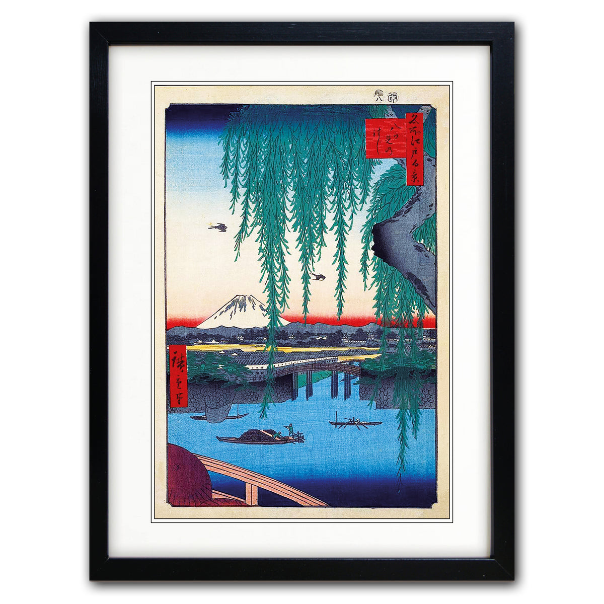 A framed art print featuring a Japanese ukiyo-e woodblock illustration of Mount Fuji, a bridge, boats, and hanging willow branches, presented in a black frame with a white mat on a light gray background.