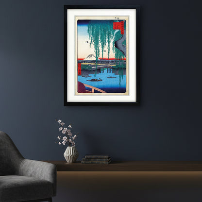 A framed art print featuring a Japanese ukiyo-e woodblock illustration of Mount Fuji, a bridge, boats, and hanging willow branches, presented in a black frame with a white mat on a light gray background.