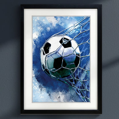 Framed wall art featuring a soccer ball striking a net, rendered in a blue watercolor style, shown against a dark gray wall.