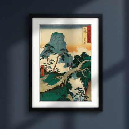 Framed Japanese style mountain landscape art print with winding path, shown against a plain dark blue
 background.