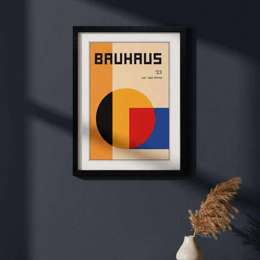 A framed Bauhaus '23 art print featuring a minimalist geometric design with orange, beige, yellow, red, and blue blocks, presented in a black frame against a white background.