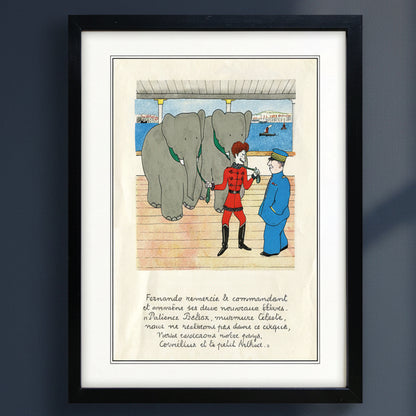 Framed vintage French cartoon print featuring an elephant trainer in a red uniform interacting with a large gray elephant on a ship deck, with a caption below, shown in a black frame with white matting against a dark gray wall.