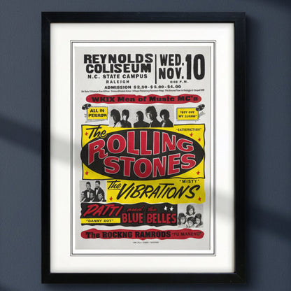Vntage gig poster print in a black picture frame hung on a dark blue wall 