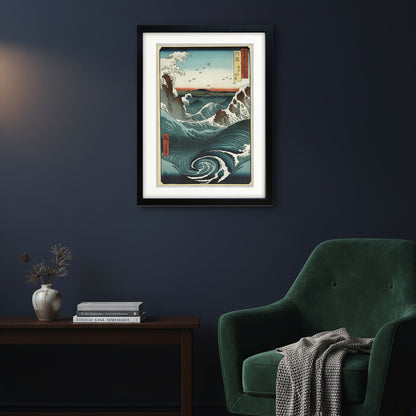 A framed Japanese-style wave artwork hanging on a white wall. The print shows large blue and white ocean waves, dark rocky shorelines, a pale sky, and small red vertical label panels with Japanese text.