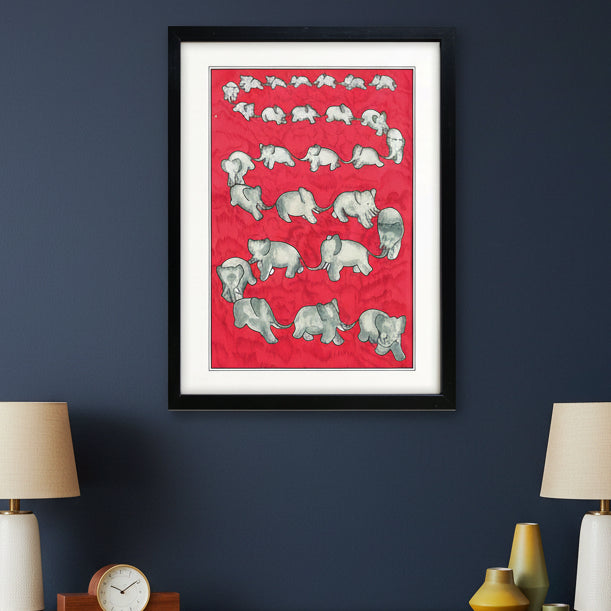 Framed wall art featuring a red background with a repeating pattern of gray baby elephants, presented in a black frame with a white mat.