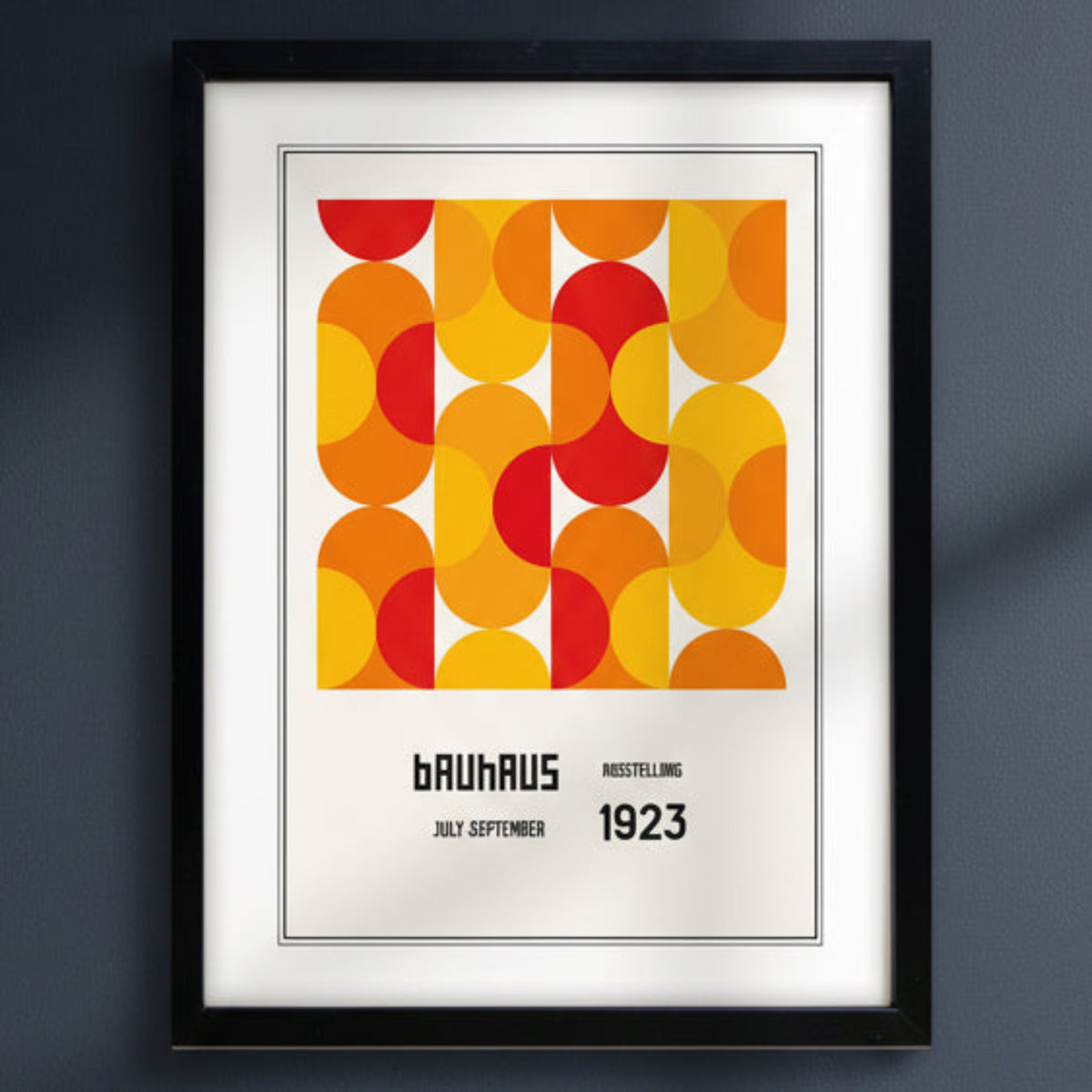 A framed Bauhaus poster featuring a bold mid-century geometric pattern in orange, yellow, and red, with the text 'BAUHAUS RUSSELLING JULY-SEPTEMBER 1923' below, shown in a black frame against a white background.