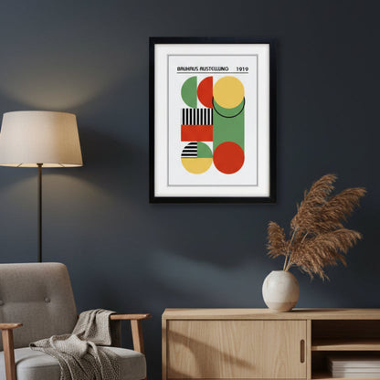 A framed Bauhaus art print from 1919 featuring abstract geometric shapes in green, red, yellow, and black-and-white stripes, presented in a black frame against a white background.