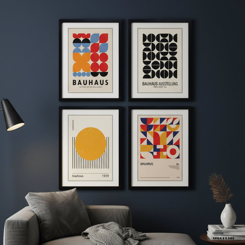 Four framed Bauhaus art prints arranged in a 2x2 grid on a white background. The prints feature abstract geometric designs in red, blue, yellow, black, and beige, with the words 'BAUHAUS' and 'Bauhaus Ausstellung' visible on two of the frames.
