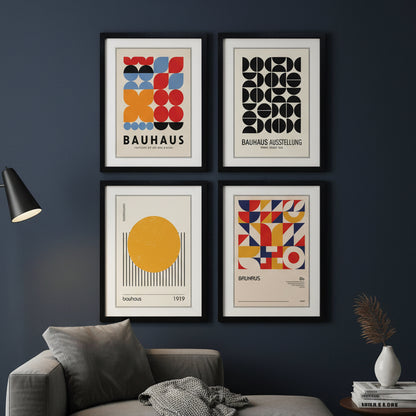 Four framed Bauhaus art prints arranged in a 2x2 grid on a white background. The prints feature abstract geometric designs in red, blue, yellow, black, and beige, with the words 'BAUHAUS' and 'Bauhaus Ausstellung' visible on two of the frames.