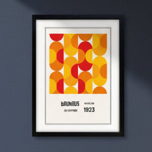 A framed Bauhaus poster featuring a bold mid-century geometric pattern in orange, yellow, and red, with the text 'BAUHAUS RUSSELLING JULY-SEPTEMBER 1923' below, shown in a black frame against a dark blue background.