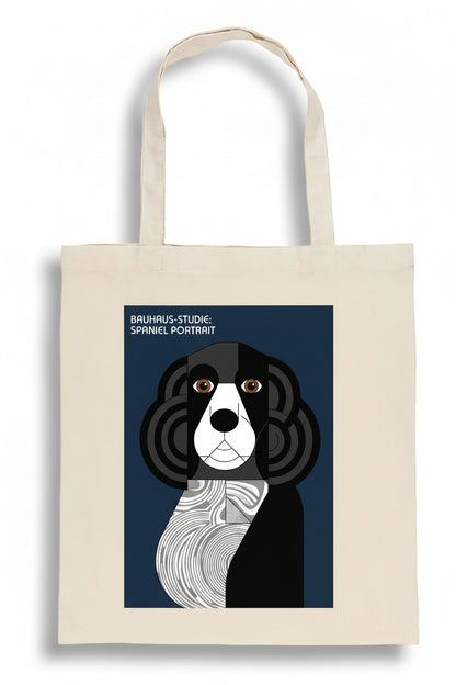 A cream-colored canvas tote bag featuring a stylized portrait of a black and white dog in an expressionist, Piet Mondrian-inspired geometric color block design. The text 'BRAUMUS-STUDIO-SPINNEL PORTRAIT' is printed above the dog.