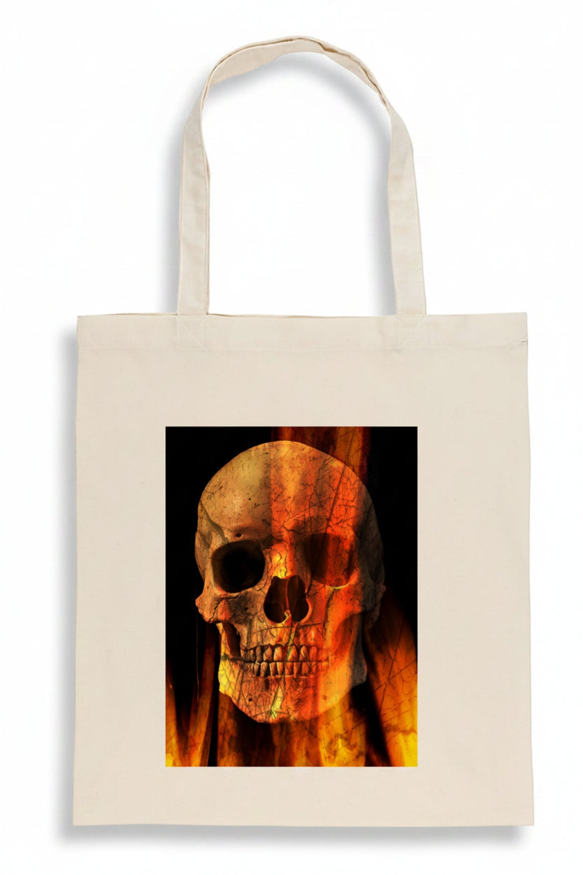 A cream-colored canvas tote bag featuring a square graphic print of a skull overlaid with orange and yellow flames on a black background.
