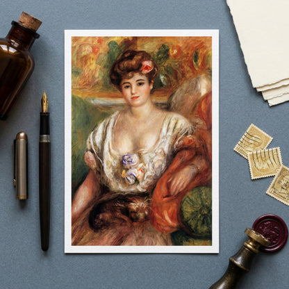 A framed art print of a classic impressionist portrait of a woman with a cat, styled in a flat-lay on a slate blue background with vintage props including a bottle, fountain pen, stamps, and wax seal.