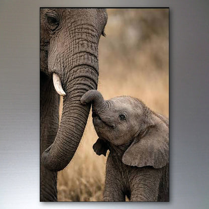 A vertical photographic art print depicting a close-up of a baby elephant touching its mother's trunk, set against a blurred natural background, shown with a dark frame on a gray gradient background.