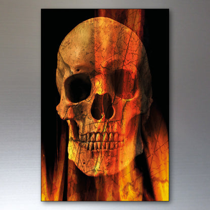 A vertical rectangular wall fridge magnets featuring a detailed human skull overlaid with fiery orange, yellow, and red crackled textures against a dark background, shown hanging on a metallic gray wall.