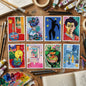 Set of eight colorful abstract and expressionist paintings arranged in two rows of four on a light gray wall. The artworks feature bold colors, geometric shapes, silhouettes, portraits, and still-life scenes in blue, red, yellow, green, pink, and black.