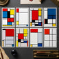 Set of eight Piet Mondrian-style geometric wall art panels arranged in two rows on a white background. The abstract canvases use black grid lines with blocks of white, red, yellow, blue, black, and gray.