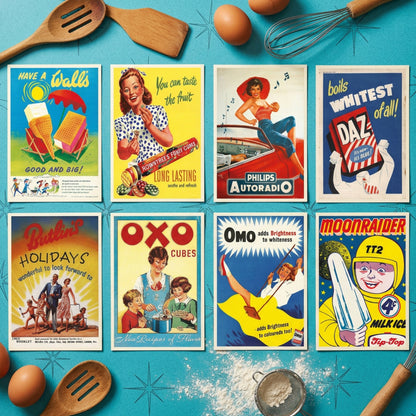 A set of eight vintage-style illustrated posters arranged in a 2x4 grid on a black background. The posters feature retro mid-century designs with bold text and colorful scenes, including slogans like 'Have a Wall's Good and Big!', 'You can taste the fruit', 'Philips Autoradi', 'Boils whitest of all!', 'Berlin! Holidays', 'Oxo Cubes', 'Omo adds Brightness to wilderness', and 'Moonraider TT2 Top Toy'.