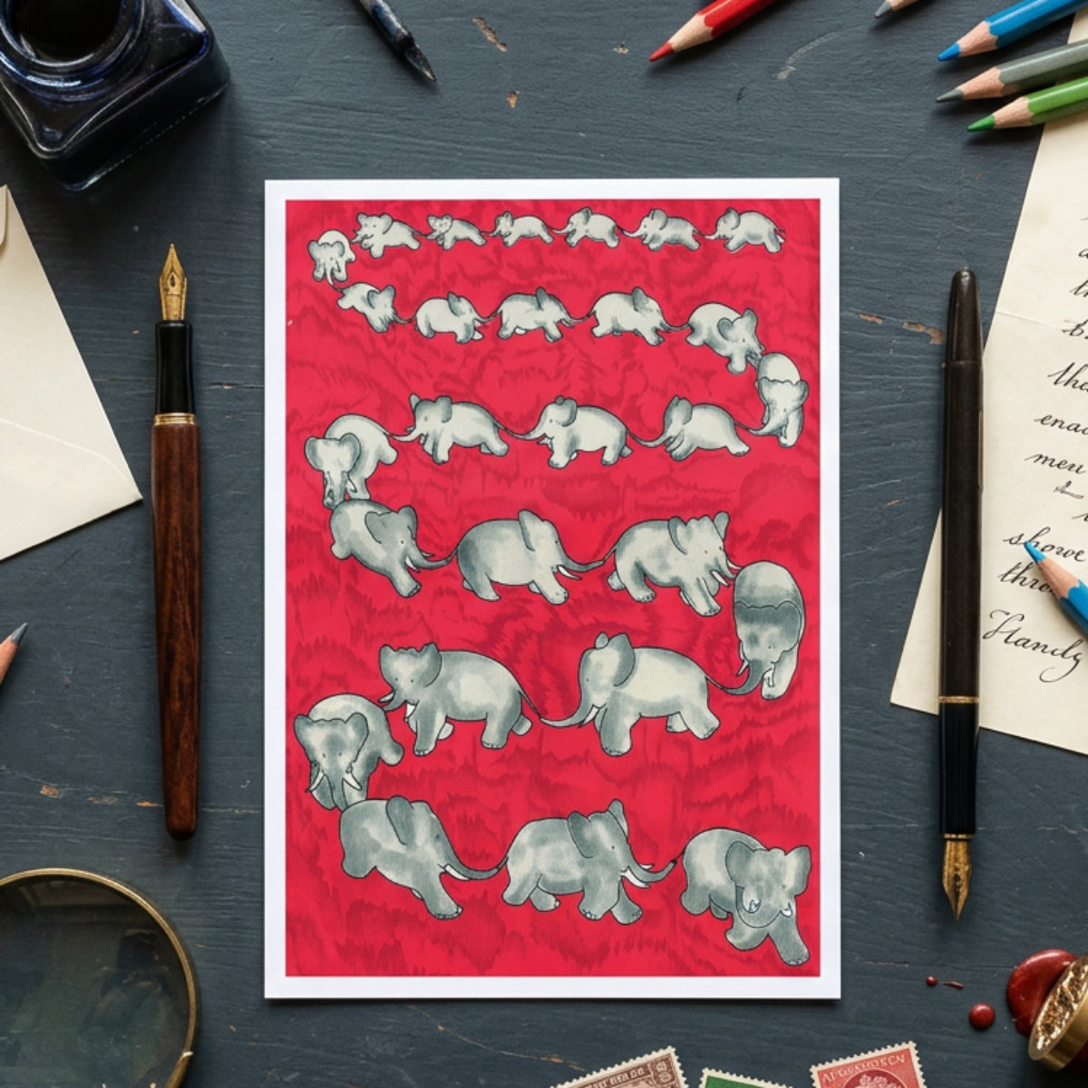 A square textile or fabric pattern featuring multiple gray baby elephants arranged in rows on a bright red background.