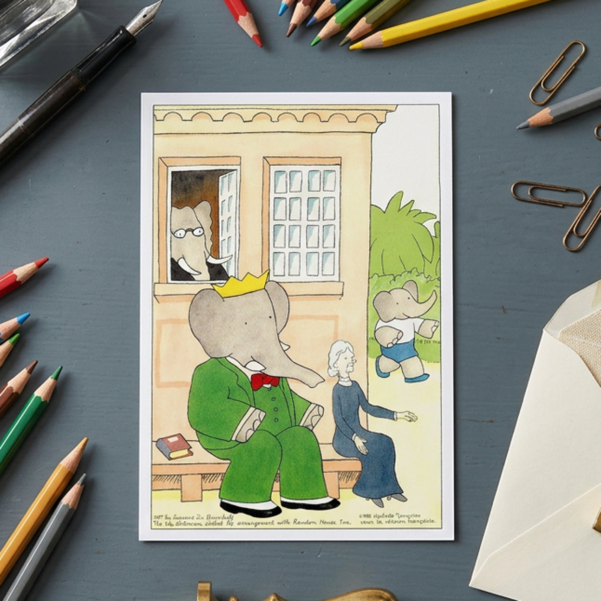 A colorful cartoon illustration featuring a gray elephant in a green suit and gold crown sitting on a bench, with another elephant running in the background, a seated woman beside him, and a building exterior with windows behind them.
