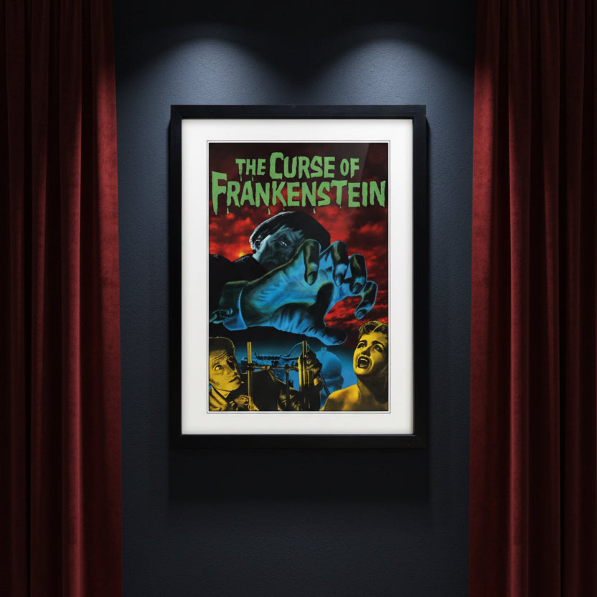 Framed vintage-style poster for 'The Curse of Frankenstein' with a black frame, white mat, and a dramatic illustration featuring a giant blue hand, red sky, and green title text.