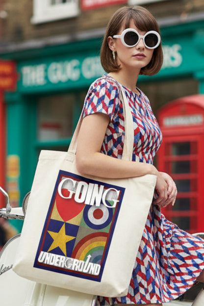 A cream-colored canvas tote bag featuring a colorful graphic print on the front with the words 'GOING UNDERGROUND' and a retro target, star, and rainbow design.
