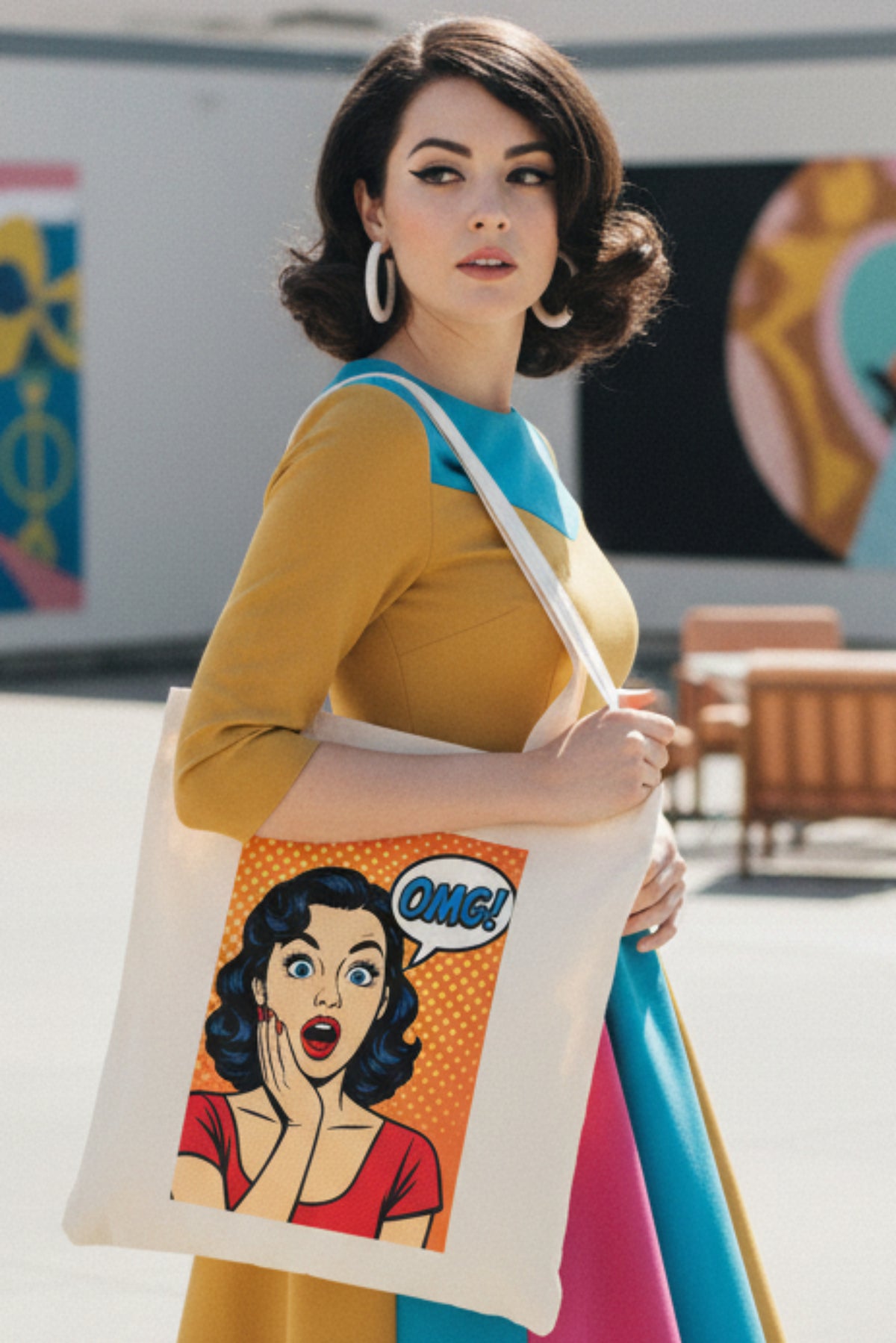 A cream-colored canvas tote bag featuring a retro pop-art graphic of a surprised woman with a speech bubble that says 'OMG!' on a solid white background.