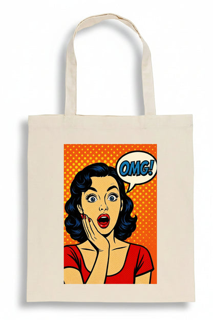 A cream-colored canvas tote bag featuring a retro pop-art graphic of a surprised woman with a speech bubble that says 'OMG!' on a solid white background.