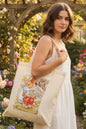 A natural canvas tote bag featuring a printed watercolor illustration of Peter Rabbit and his mother on the front, set against a plain white background.