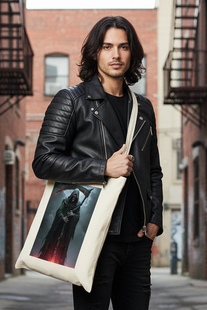 A cream-colored canvas tote bag with a large graphic print of a hooded grim reaper holding a scythe with glowing red blades, set against a plain white background.